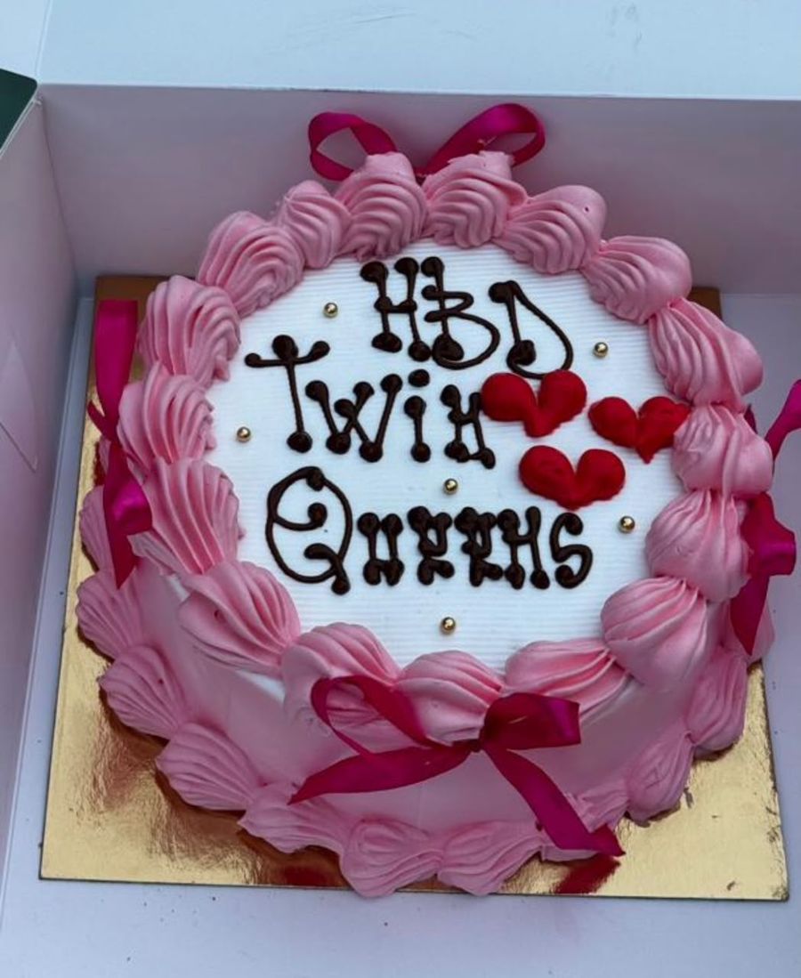 Gâteau rose et blanc avec rubans et cœurs rouges